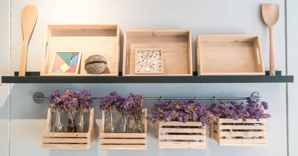 Wooden trays and grill placed on a kitchen shelf.